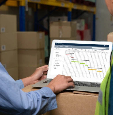 Maintenance engineers reviewing MRO work schedule on laptop for equipment reliability planning